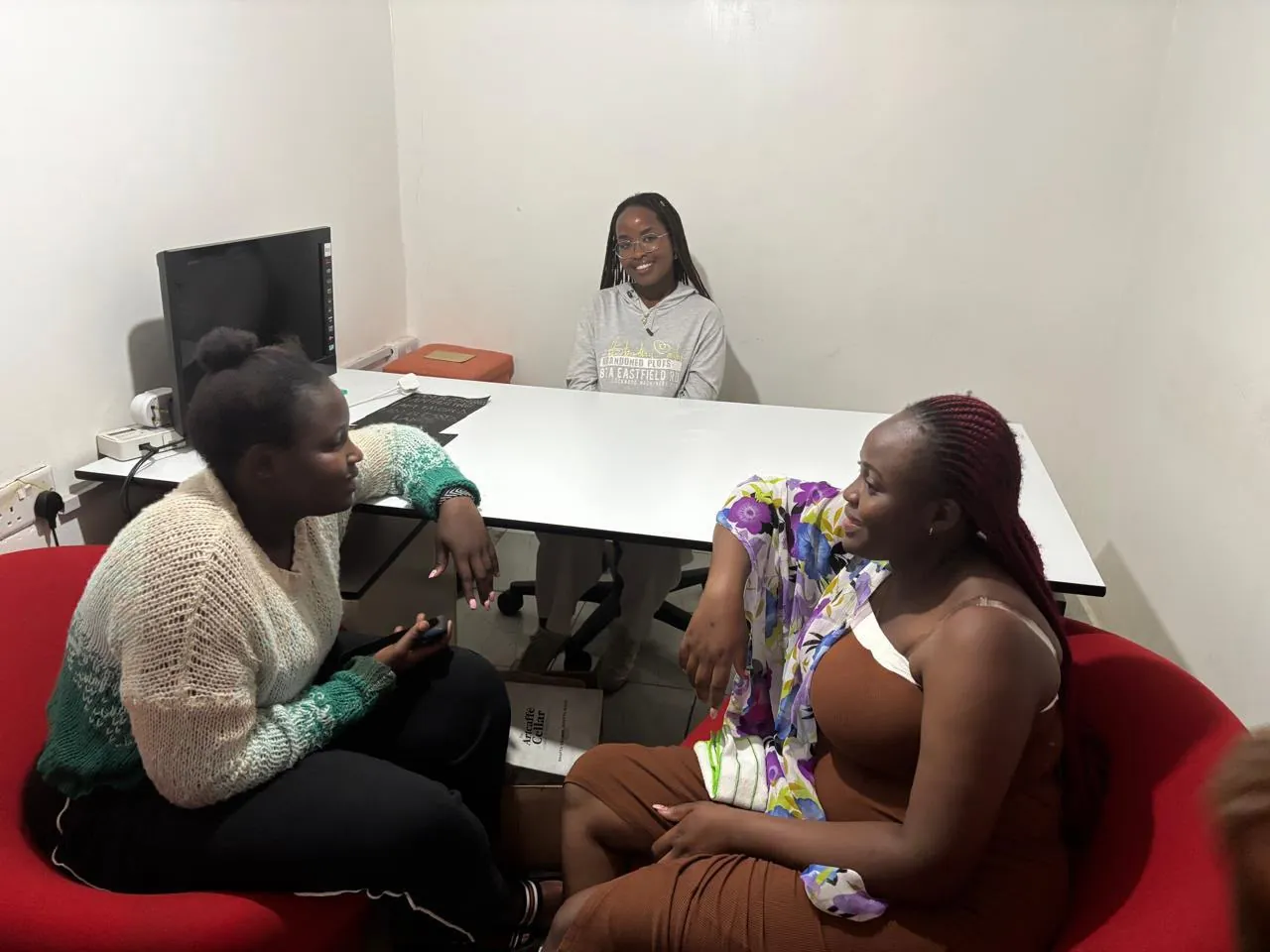 Three young women talking together in the office during a mentorship session